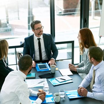 Business meeting with five professionals around a table.