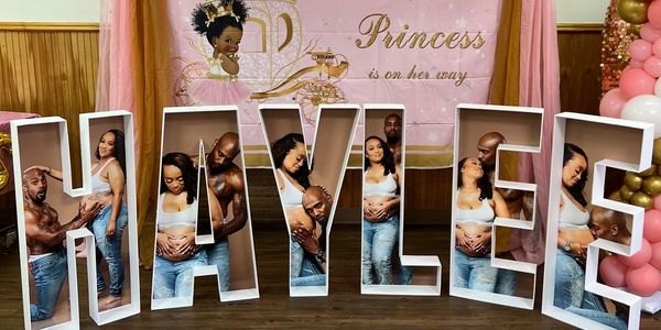 Couple celebrating pregnancy with personalized name display.