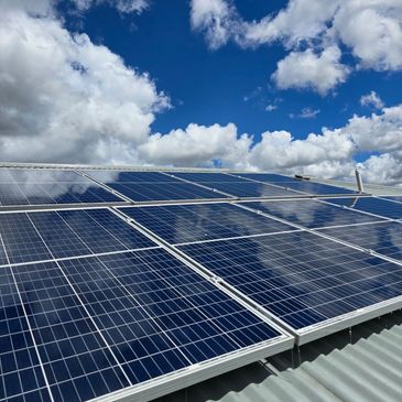 Solar panels under a partly cloudy sky.