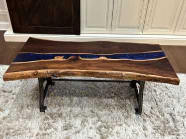 Wood and blue resin coffee table on a rug.