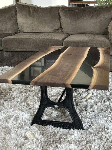 Modern wood and resin coffee table with industrial metal base.