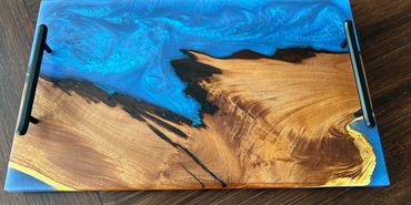 Wood and blue resin serving tray with black handles.