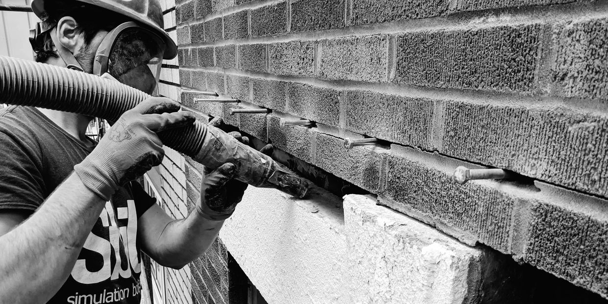 Remplacement d'un linteau de pierre fissuré sur une façade en brique