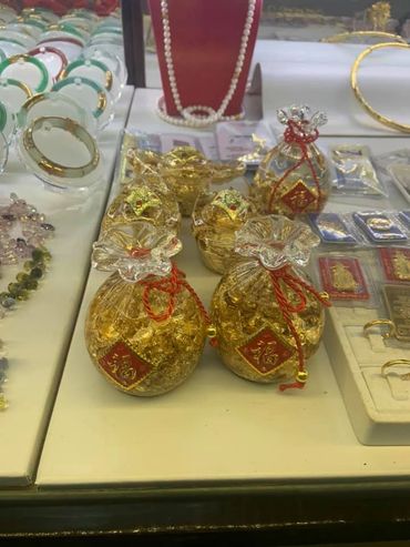Decorative gold pouches with red accents displayed in a jewelry showcase.