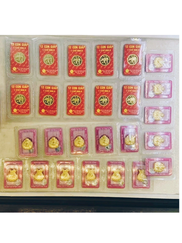 Collection of gold bars and gold animal figurines in plastic cases.