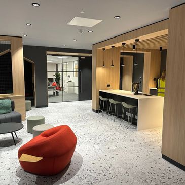 Modern office lounge with stylish seating and wooden accents.