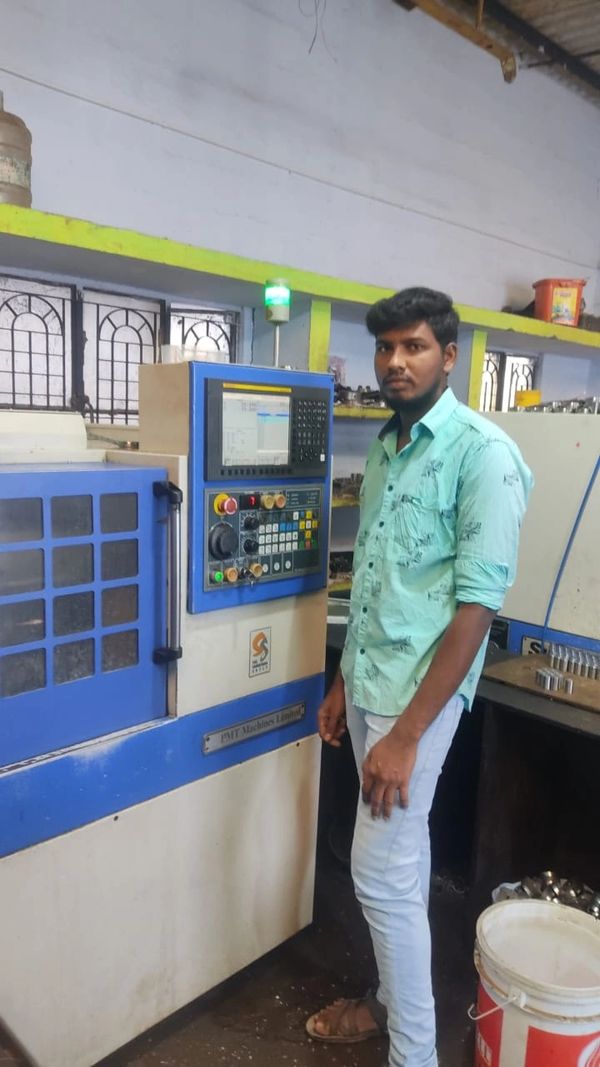 Man operating a CNC machine in an industrial setting.