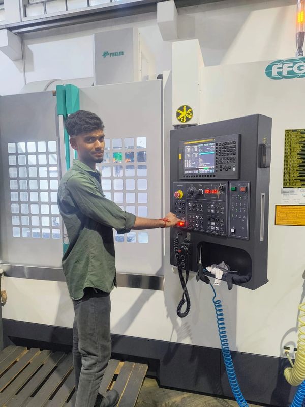 Man operating an industrial CNC machine in a workshop.