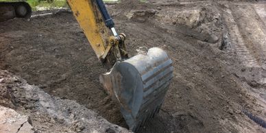Site Grading Design.  Photo showing an excavator modifying a bank slope.
