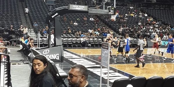 Basketball game with players on the court and spectators in seats.