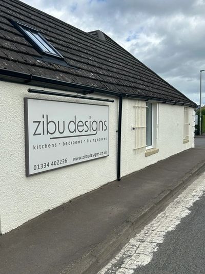Sign for Zibu Designs on a white building.