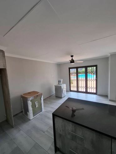 Minimalist room with large window and packaged appliances.