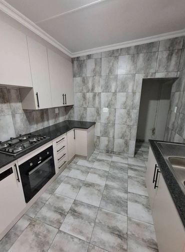 Modern kitchen with marble tiles and sleek cabinetry.