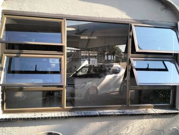 Car reflected in a multi-panel window with three open sections.