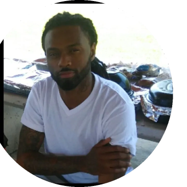 Man in white t-shirt sitting with arms crossed.