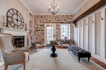 The historic inn has a quaint service entry and reading room with an exposed stone wall.