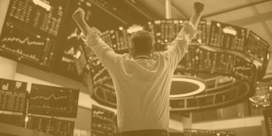 Trader celebrating success with upward graphs.