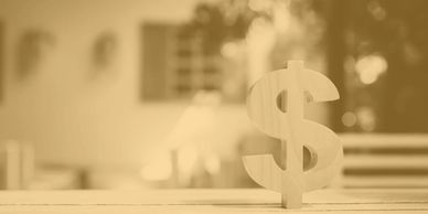 Wooden dollar sign on a table.