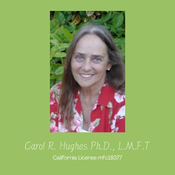 Portrait of a smiling woman against a green leafy background.