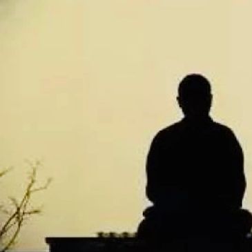 Silhouettes of two people against a large circular light.