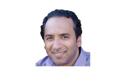 Smiling man with short curly hair.
