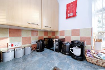 A tidy kitchen corner with appliances and storage jars.