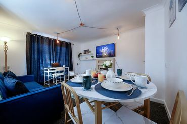 Cozy living and dining area with blue accents and modern decor.