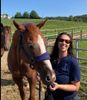 Gillian posing with Jordan, another chestnut Ottb with a white blaze. Another horse is in the back