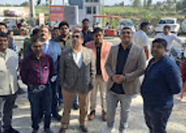 A group of men posing outdoors in casual and formal attire.