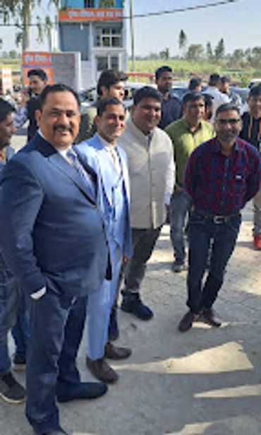 Group of men standing outdoors, some in formal wear.