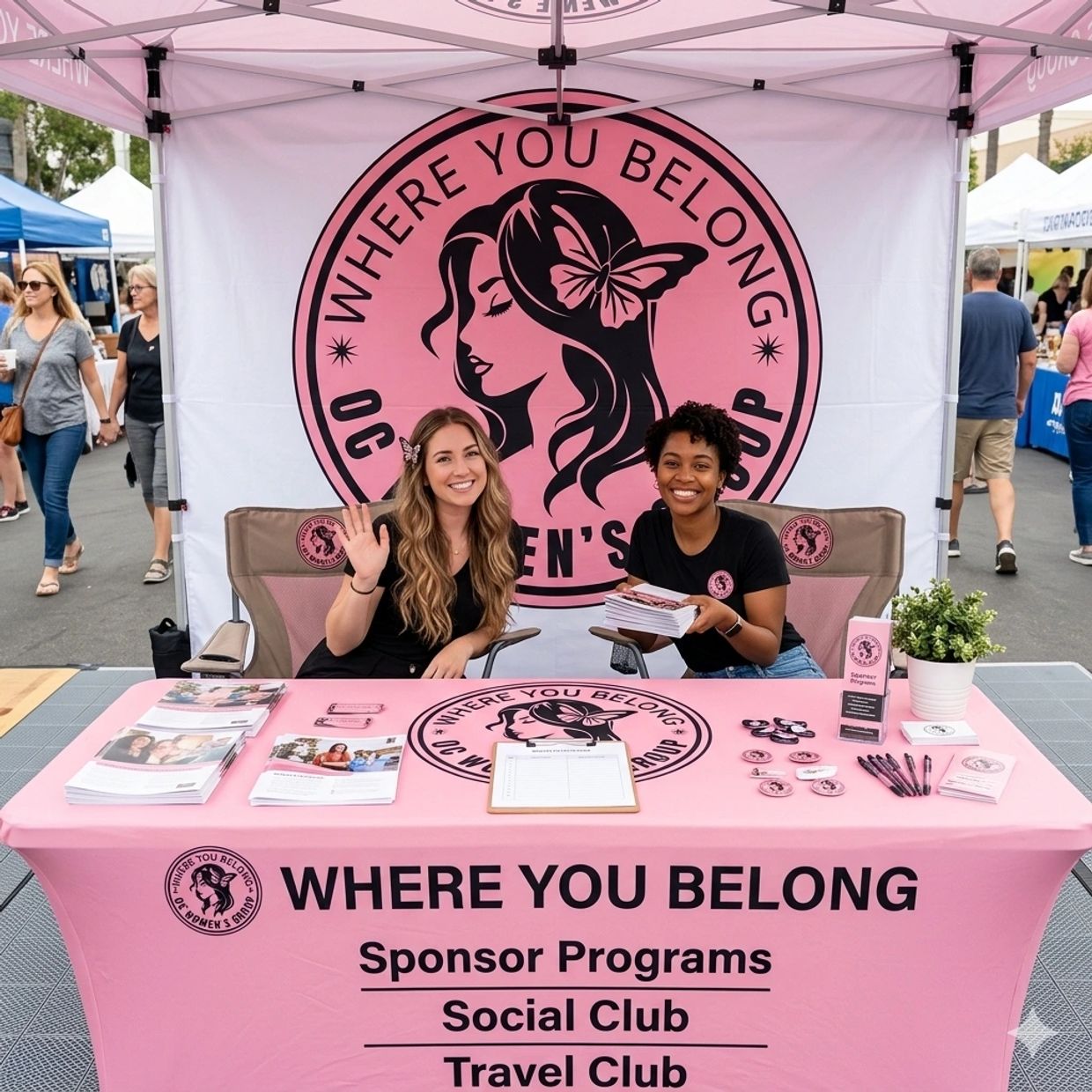 Two women smiling at a women's group information booth with promotional materials.