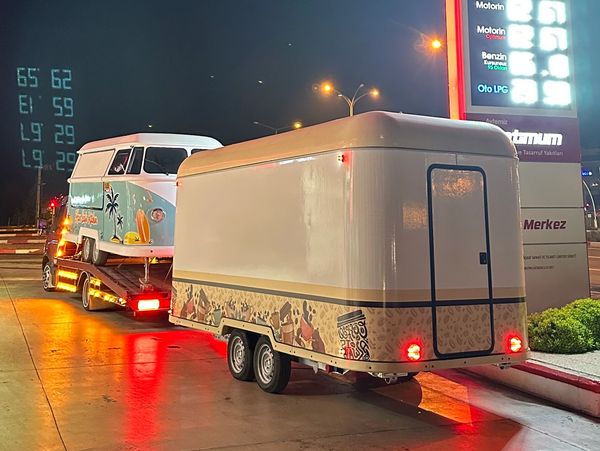 Vintage van being transported on a trailer at night.