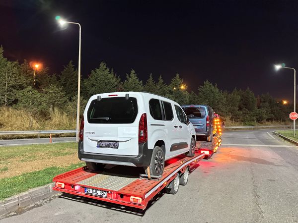 Gece yolunda beyaz Citroen araçlı araç taşıyıcı.