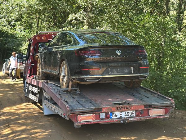 Ormanda çekiciye yüklenen siyah Volkswagen Arteon.