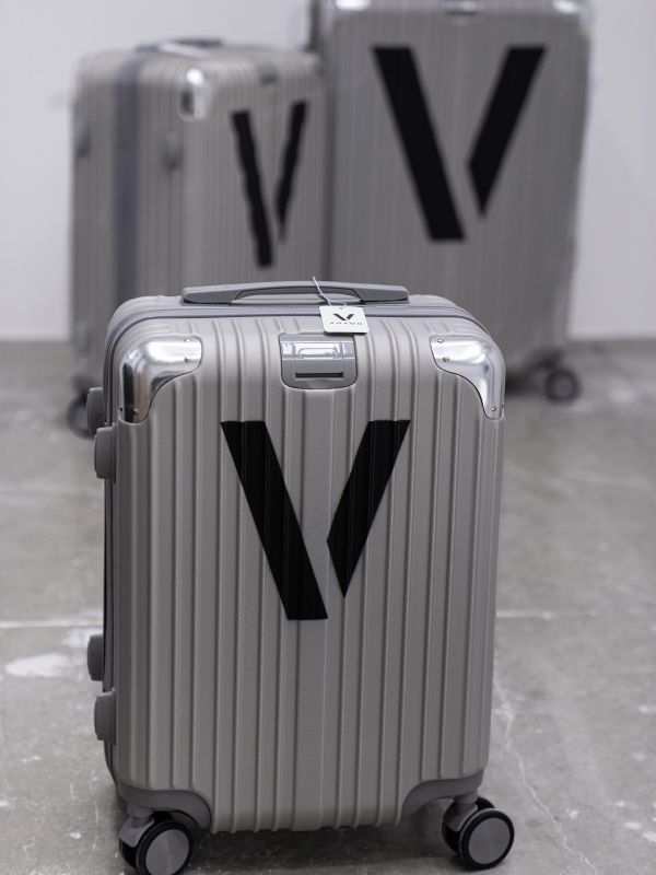 Three silver suitcases with black 'V' logo.
