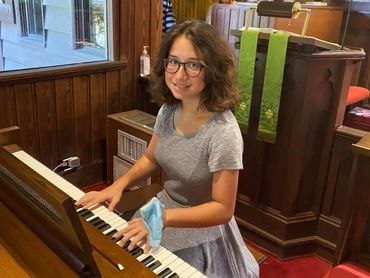 Female child playing piano at church.