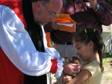 Episcopal bishop blessing a child and her pet.