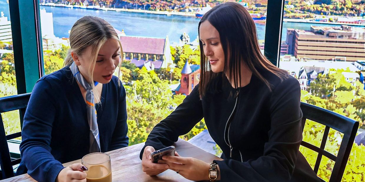 A real estate agent shows her female client new home listings at the Rooms Cafe in St. John's