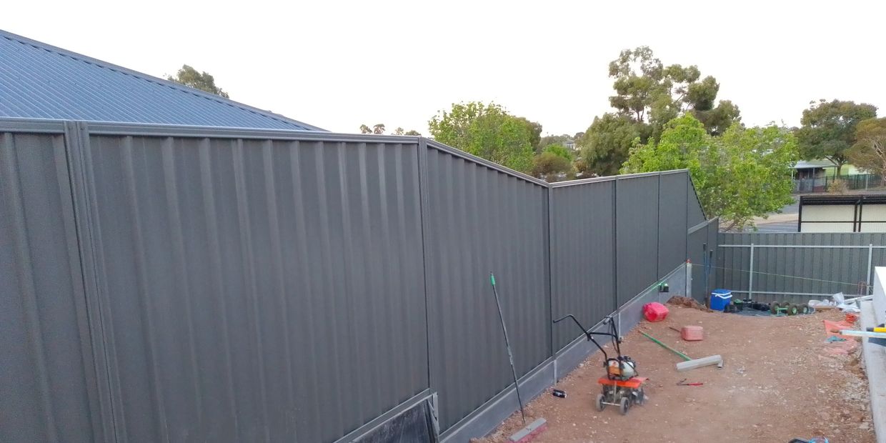woodlands grey good neighbour fencing attached to retaining wall by designer paving and landscaping