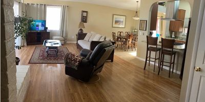 Spacious living room with wooden flooring and comfortable seating.