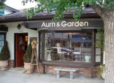 Charming garden-themed store named 'Aum & Garden' with rustic decor and large window display.