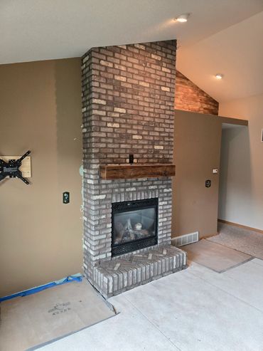 Brick fireplace using rustic brick, herringbone design on hearth.