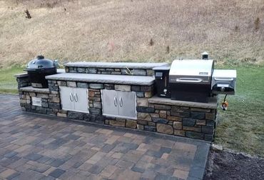 Outdoor kitchen with built in grills and stainless steel doors. Counters are made out of Indiana Li
