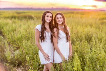 long haired twin girls against beautiful sunset