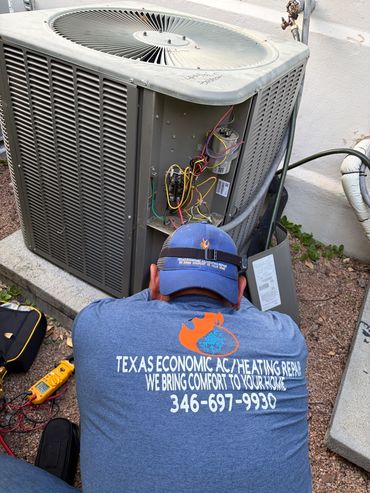 Technician repairing air conditioning unit outdoors.
