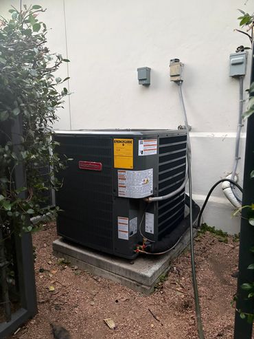 Goodman air conditioning unit outside a house.