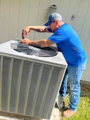 Technician fixing an air conditioning unit.
