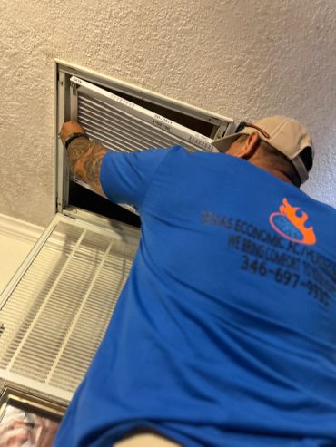 Man changing air filter indoors.