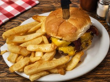 Cheeseburger with fries on a white plate.