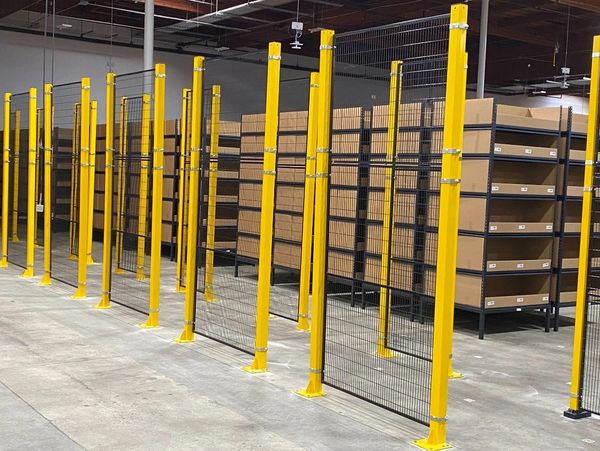 Warehouse shelving units with yellow safety barriers and cardboard boxes.
